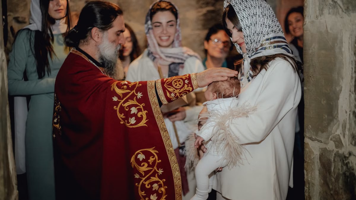 A touching baptism ceremony with priest, family, and friends in a church.